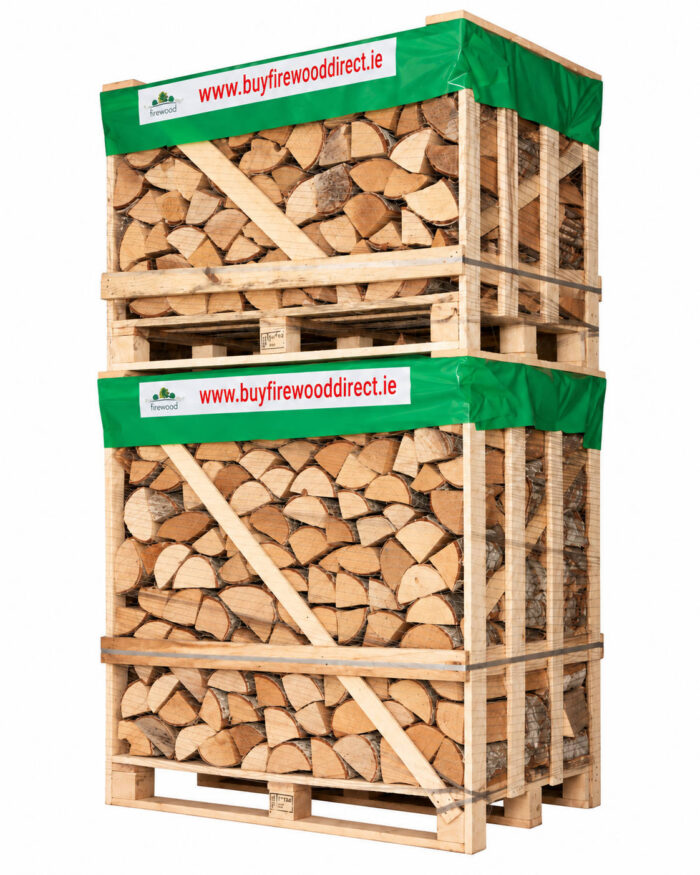 Stacked pallets of firewood with a green wrap and 'www.buyfirewooddirect.ie' banner; organized logs ready for shipment